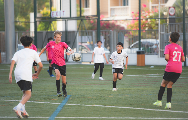 Kinder spielen Fußball in einer AG in der Schule