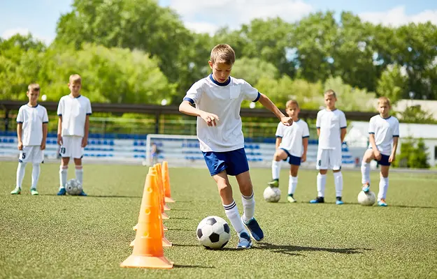 Ein Kind macht eine Fußballübung in einem Fußballworkshop in Lübeck
