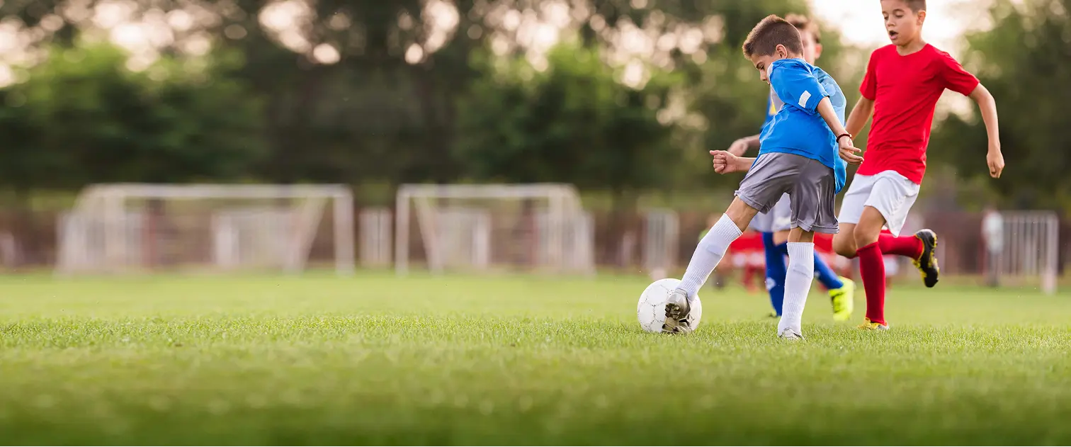 Kinder spielen Fußball zusammen