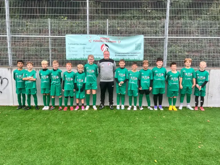 Gruppenfoto einer Trainingsgruppe mit Trainer vor dem Banner von Bodien Fußballtraining in Schwalbach