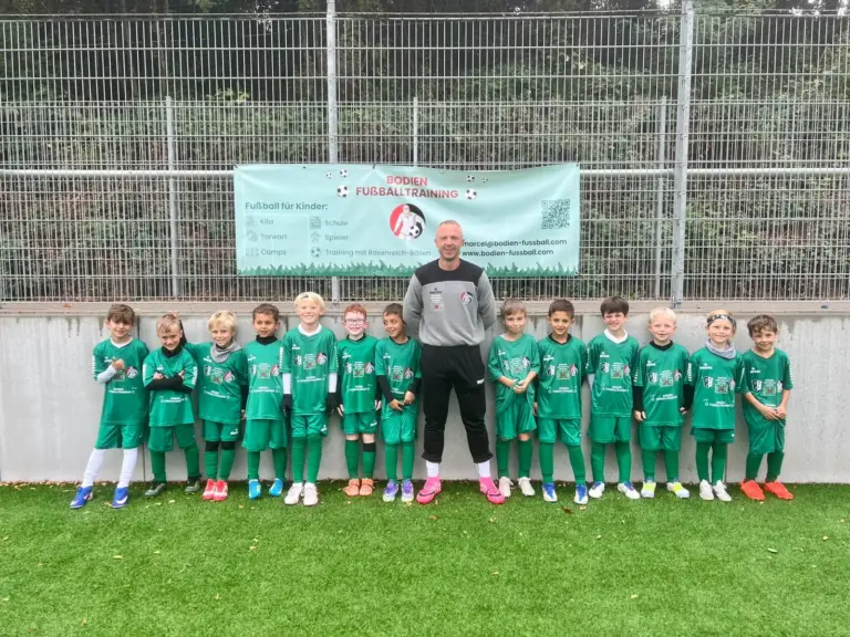 Gruppenfoto der jüngsten Trainingsgruppe mit Trainer vor dem Banner von Bodien Fußballtraining