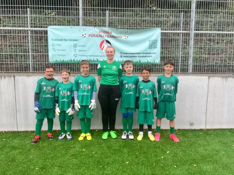 Gruppenfoto der Torwartgruppe mit Torwarthandschuhen und Trainerin vor dem Banner von Bodien Fußballtraining